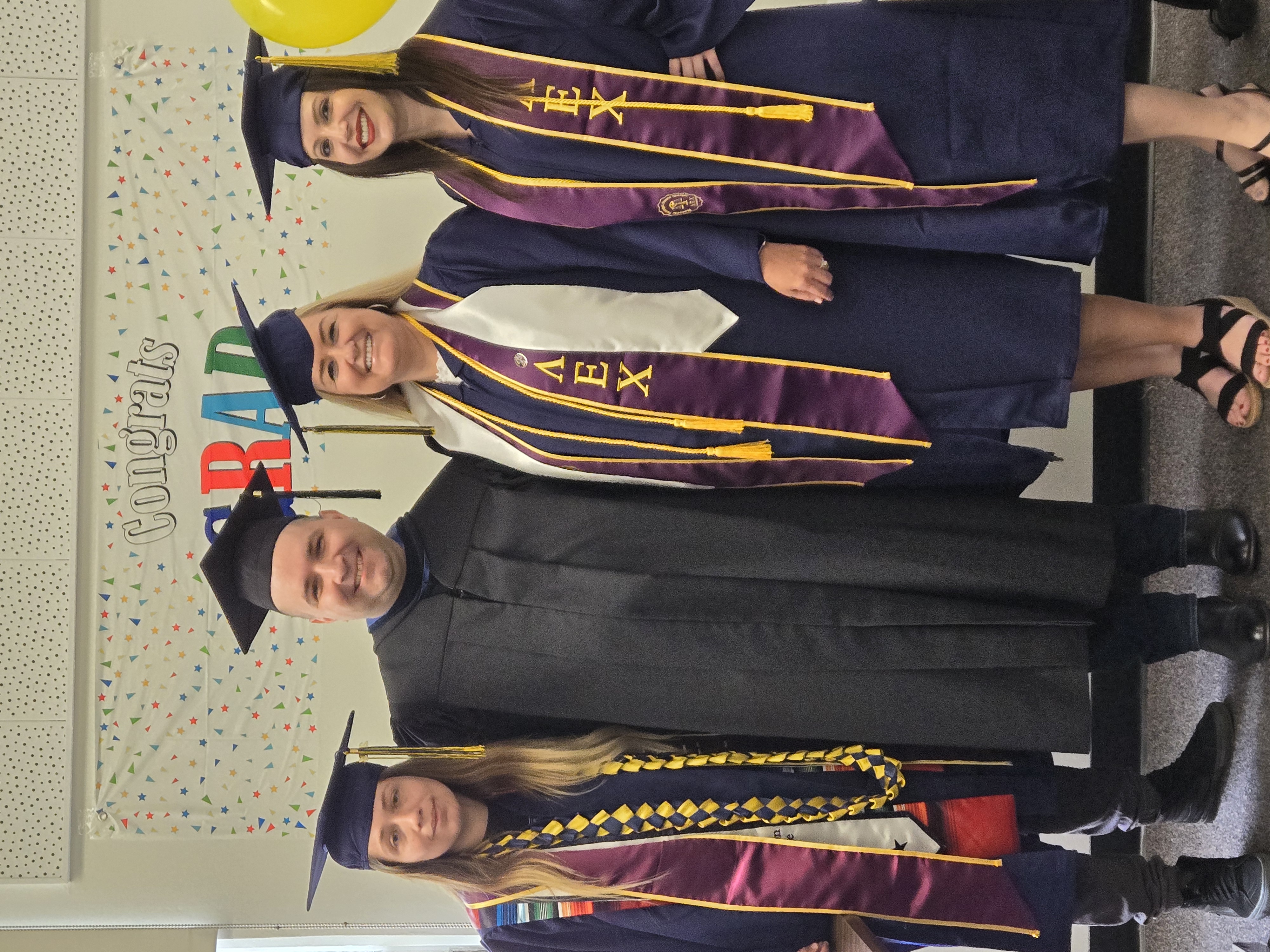 Four people in graduation garb
